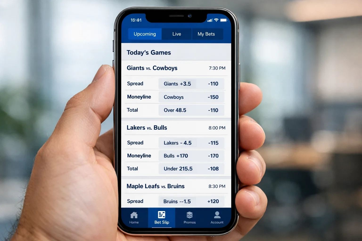 Hand holding smartphone with clean minimal sports betting interface showing game odds